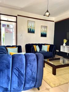 a living room with a blue couch and a table at Cozy 1br milimani in Kisumu