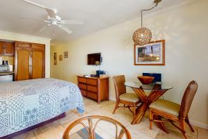 a bedroom with a bed and a table and chairs at Islander on the Beach 361 in Kapaa