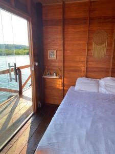 a bedroom with a bed and a view of the water at Casa Flutuante - Experiência única in Manaus