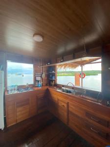 a kitchen with two large windows in a boat at Casa Flutuante - Experiência única in Manaus