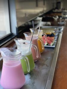 a row of cups filled with different colored drinks at Hotel Vitória in Vitória da Conquista +17 photos