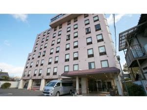 a large building with a van parked in a parking lot at Kanku Sun Plus Yutaka - Vacation STAY 38978v in Izumi-Sano