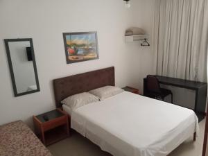 Habitación de hotel con cama y espejo en Solar da Praia, en Vitória