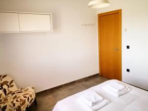 a room with a bed and a chair and a door at Casa Rural Paraje Valdefuentes ** in Montehermoso +24 photos