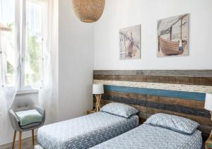 a bedroom with two beds and a chair at La Meria di Maria La Terrazza in Marina di Grosseto