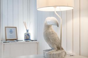 posąg ptaka siedzącego na stole obok lampy w obiekcie Chiado 44 w Lizbonie