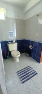 a bathroom with a toilet and a blue tiled wall at Casa Agua Bacalar / Naajil Ha in Bacalar