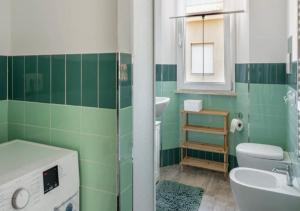 a green and white bathroom with a sink and a toilet at La Meria di Maria La Terrazza in Marina di Grosseto +28 photos