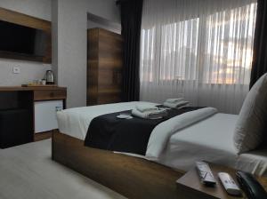 a hotel room with a bed and a television at Acar Airport Hotel Plus in Arnavutköy