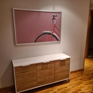 una pintura de una bicicleta en una pared sobre un tocador en Apartamento El Mirador, en Villaviciosa