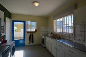 una cucina con armadi bianchi e una porta blu di The Julianadorp Villas a Willemstad