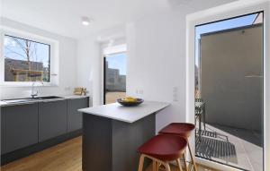 a kitchen with a counter and two stools at Beach Front Home In Lembruchdümmer See in Lembruch +32 photos