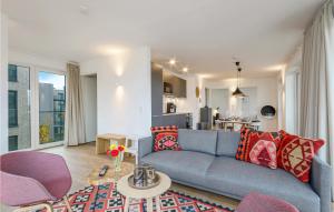 a living room with a blue couch and a kitchen at Stunning Apartment In Lembruch-dmmer See With Lake View in Lembruch