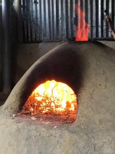 a pizza oven with a fire in it at Lala Elyacout in Azzaba