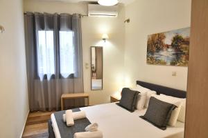 a bedroom with a white bed with a window at Giorgos House in Nafplio