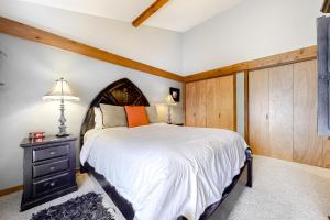 1 dormitorio con 1 cama grande y pared de madera en Golf Creek12 en Teton Village