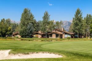 um campo de golfe com uma casa ao fundo em Golf Creek 16 em Teton Village