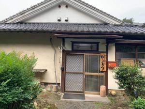 a house with a door and a window at ゲストハウスやごろう in Iizuka