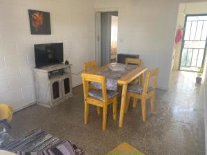 a dining room with a table and chairs and a television at Departamentos Temporales con Wifi, Tv y Aire in Oliva