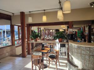 eine Bar in einem Restaurant mit Stühlen und einer Theke in der Unterkunft Coronado Hotel in Mina Clavero