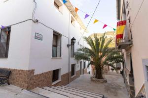 a palm tree in the middle of a street with flags at CASA RURAL BIENVENIDA in Cuatretondeta