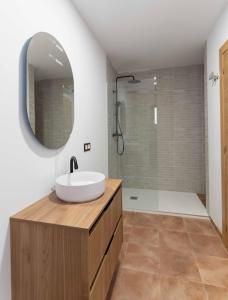 a bathroom with a sink and a shower with a mirror at CASA RURAL BIENVENIDA in Cuatretondeta