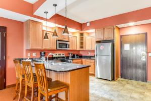 - une cuisine avec des murs orange et un réfrigérateur en acier inoxydable dans l'établissement Chula Vista 2519, à Wisconsin Dells
