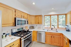 a kitchen with wooden cabinets and a stove top oven at Stratton Hollow House in Forest Farms