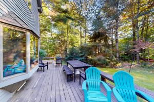 a wooden deck with chairs and a table and benches at Stratton Hollow House in Forest Farms