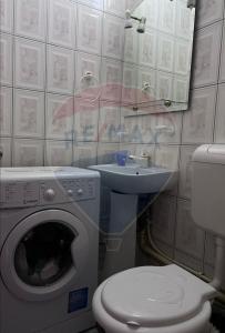 bagno con lavatrice e lavandino di NEVERSEA beachfront 2 bedroom apartament a Constanţa