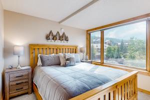 a bedroom with a large bed and a large window at Center Village Hideaway in Frisco