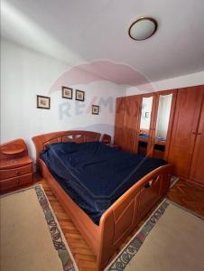 una camera da letto con un letto di legno in una stanza di NEVERSEA beachfront 2 bedroom apartament a Constanţa