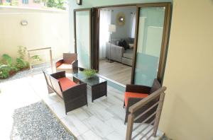 a living room with a glass table and chairs at Pen Manor Modern 2 Bedroom Apartment in Boissiere Village