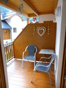 einen Balkon mit 2 Stühlen, einem Tisch und einem Herzschild in der Unterkunft Daniela 10 by SMR Rauris Apartments - inc Spa and National Summercard - near Gondola in Rauris