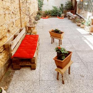 パレルモにあるCasa Peppyの赤いソファと鉢植えの植物が備わるパティオ