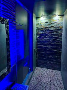 ein Badezimmer mit einer Dusche mit blauer Beleuchtung in der Unterkunft loveroom21 in Valenciennes