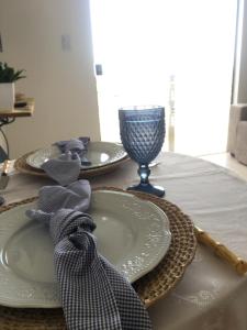 uma mesa com dois pratos e um copo de vinho em Sua casinha de férias em Icapui CE em Icapuí