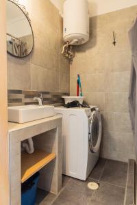 ein Badezimmer mit einer Waschmaschine und einem Waschbecken in der Unterkunft Modiano Studio ΙΙΙ By Socrates Junior Houses in Thessaloniki
