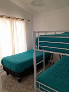 a bedroom with two bunk beds and a window at Cabanas bahia inglesa in Bahia Inglesa