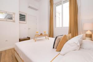 2 łóżka w białym pokoju z oknem w obiekcie BHost - NIño Guevara w Maladze