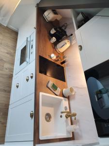 a small kitchen with white cabinets and a sink at La Palme d'Or by Madame Conciergerie in Bruz