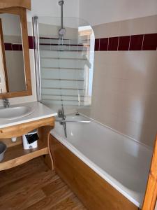 un bagno con vasca e lavandino di Melezes A a Chamrousse