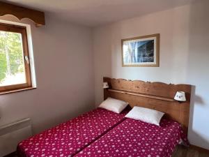 una camera da letto con un letto con una coperta rossa di Melezes A a Chamrousse