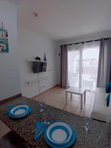 un soggiorno con tavolo e piatti blu di Apartamento La Arena a Puerto del Carmen