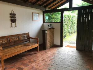 a wooden bench sitting in a room with a door at Chalés Água de Coco in Boicucanga