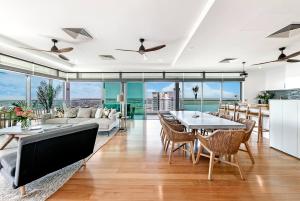 a living room with a couch and tables and chairs at Unparalleled Penthouse Luxury at Horizons 360 in Darwin