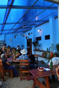 un groupe de personnes assises à des tables dans une pièce dans l'établissement Habitación Equipada a 26 kilómetros de Jaco, Tulín Azul, 