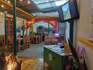 a restaurant with a tv on the wall and tables and chairs at Jardín es Tuyo in Jardin