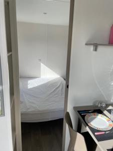 Dormitorio pequeño con cama y espejo en FILEAUX 323, en Litteau