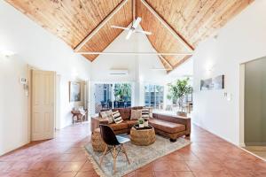 a living room with a ceiling fan and a couch at An Absolute Poolside Break by Casuarina Beach in Darwin